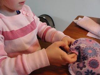 child stuffing fiber fill into easter egg pillow