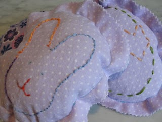 pile of easter egg shaped pillows - one with easter egg decorations and another with an easter bunny decoration
