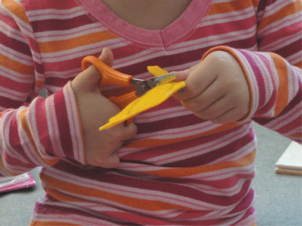 kid cutting out felt pumpkins