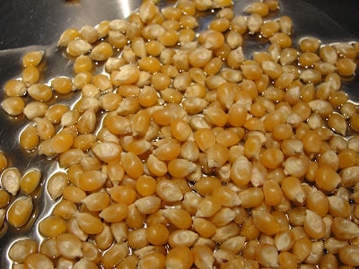 unpopped popcorn in a metal pot