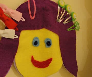 felt face hair clip holder hanging on wall