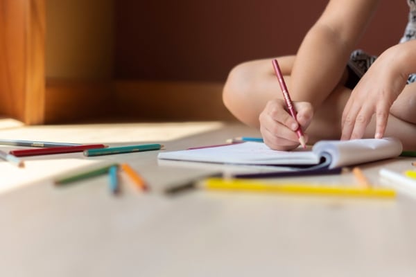 child writing in journal for International Women's Day