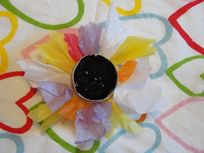 egg cup decorated with tissue paper and filled with dirt and seeds on table