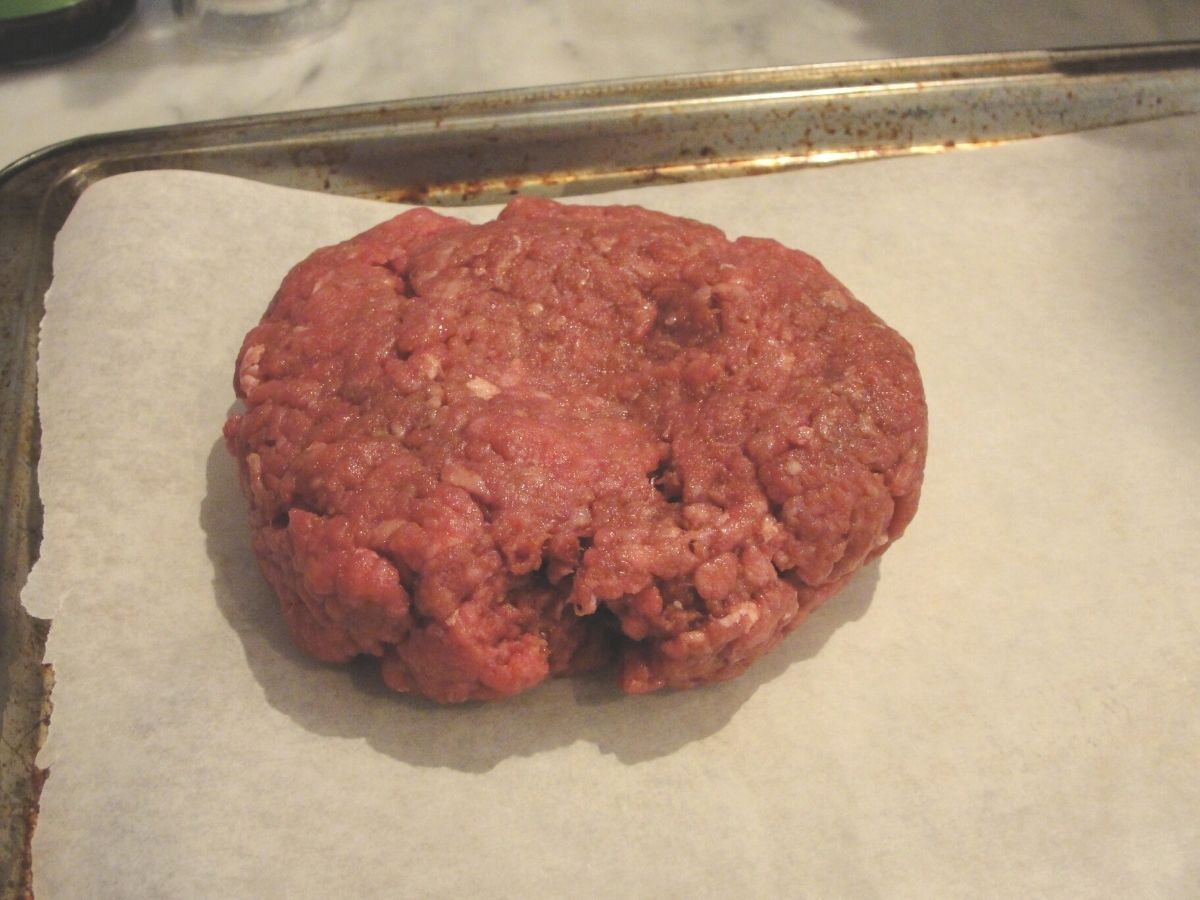 perfect beef burger on parchment paper lined baking sheet