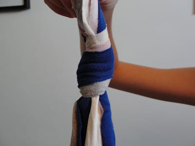 child knotting t-shirt strips