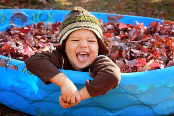 kid swimming in pool with leaves