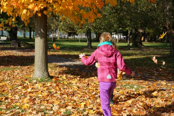 kid playing in leaves
