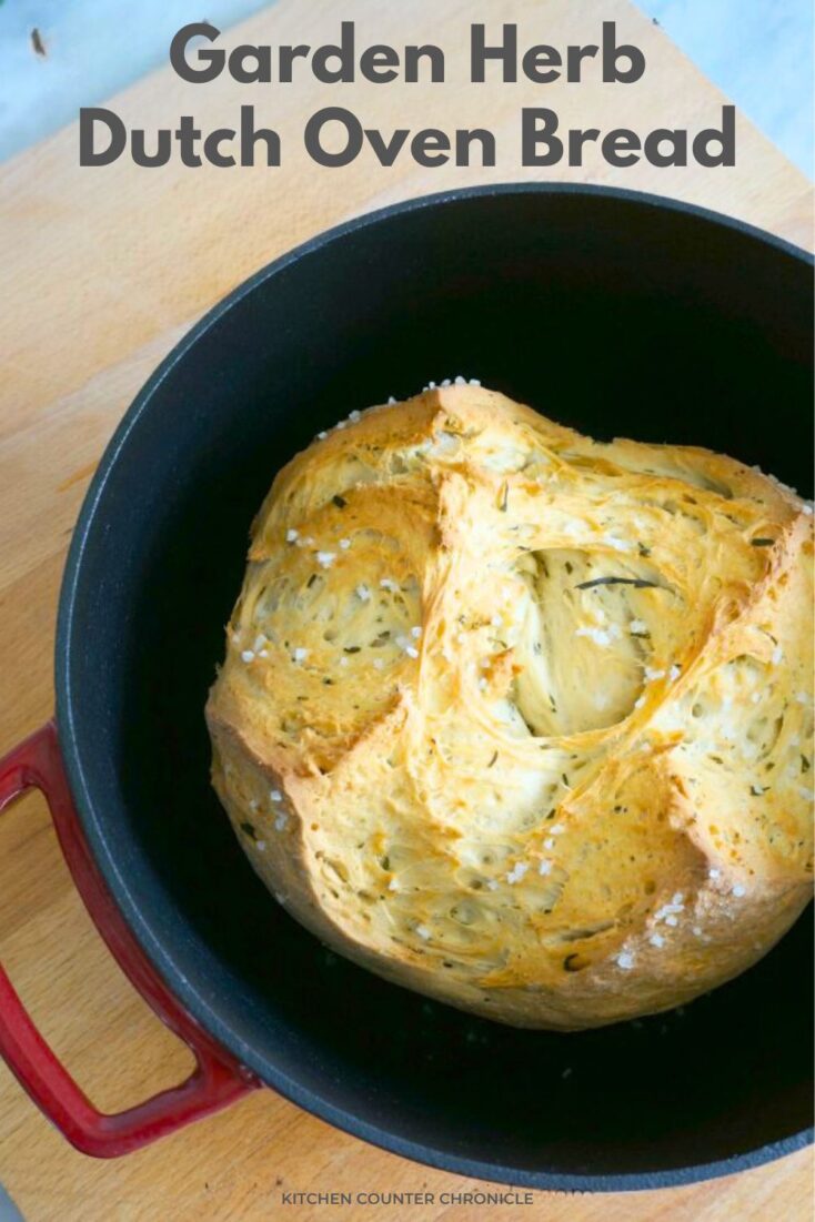 Garden Herb Dutch Oven Bread in a red dutch oven on wooden board