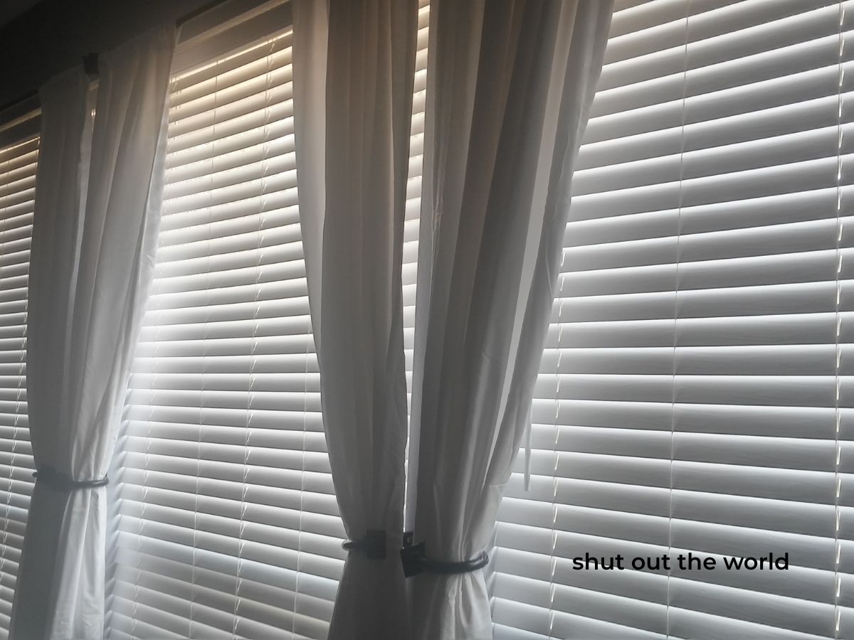 shut out the world text on image of closed blinds