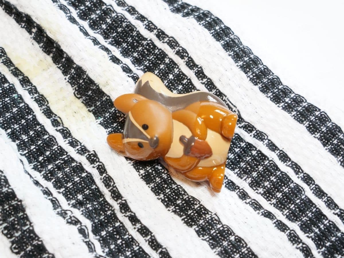 oily toy squirrel covered in oil from oil spill science experiment sitting on clean cloth