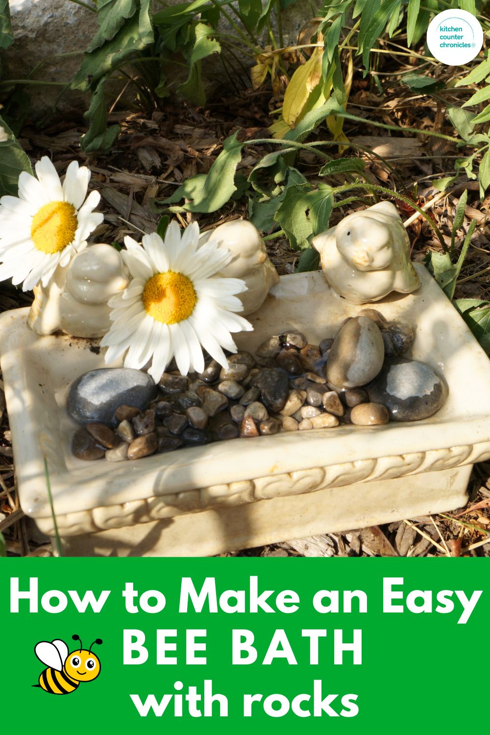 title "how to make a bee bath with rocks" image of a bee bath in a garden surrounded by plants and flowers.