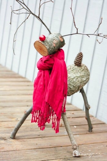 log reindeer wearing a red scarf