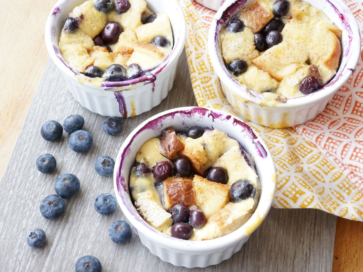 baked ramekins with blueberry bread pudding on cutting board
