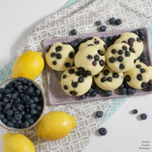 lemon blueberry pancake muffins on tray with blueberries and lemons