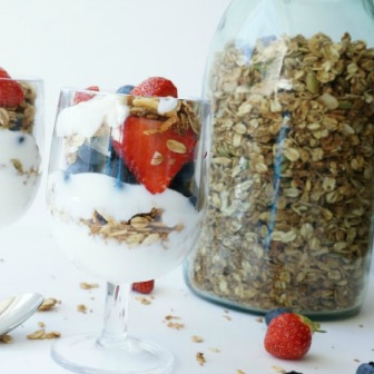 container of homemade granola and a yogurt parfait