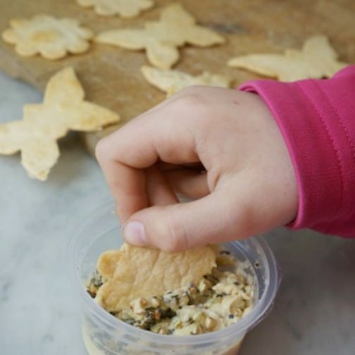 homemade tortilla chips and dip with child's hand