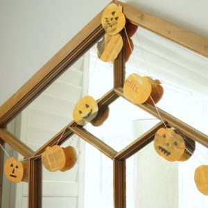 newspaper pumpkin garland hanging on mirror