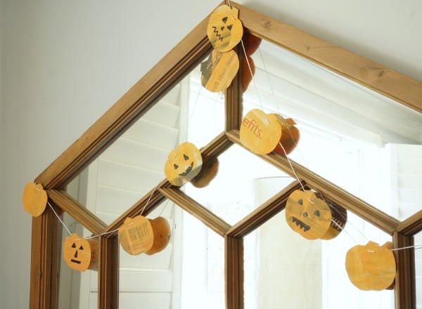 newspaper pumpkin garland hanging on mirror