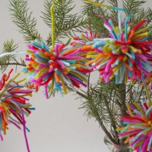 Boho Christmas Pom Pom Garland - A lovely kid-made Christmas garland inspired by Amelia from The Girl Who Saved Christmas. | #kidmadeornament #christmas #christmaskids #bohochristmas #bohopompomgarland #kidmadeornament