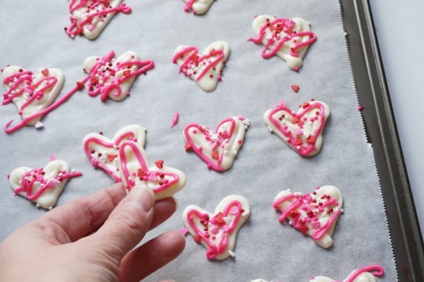 chocolate heart shaped chocolates on baking sheet being peeled off