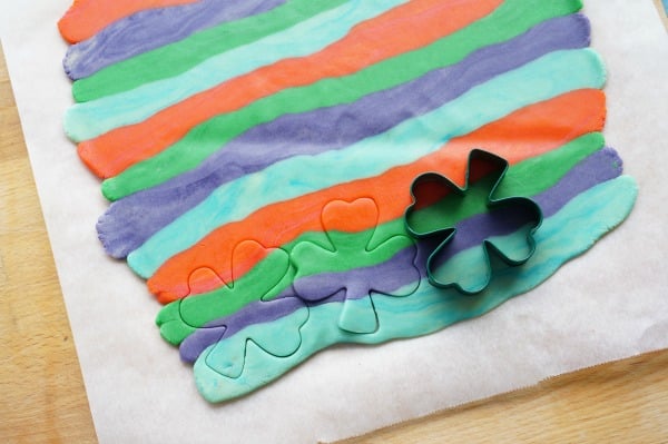 cookie cutters in rainbow cookie dough