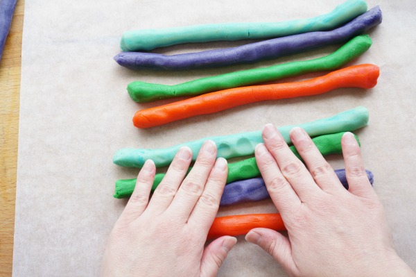 flattening coloured dough with hands