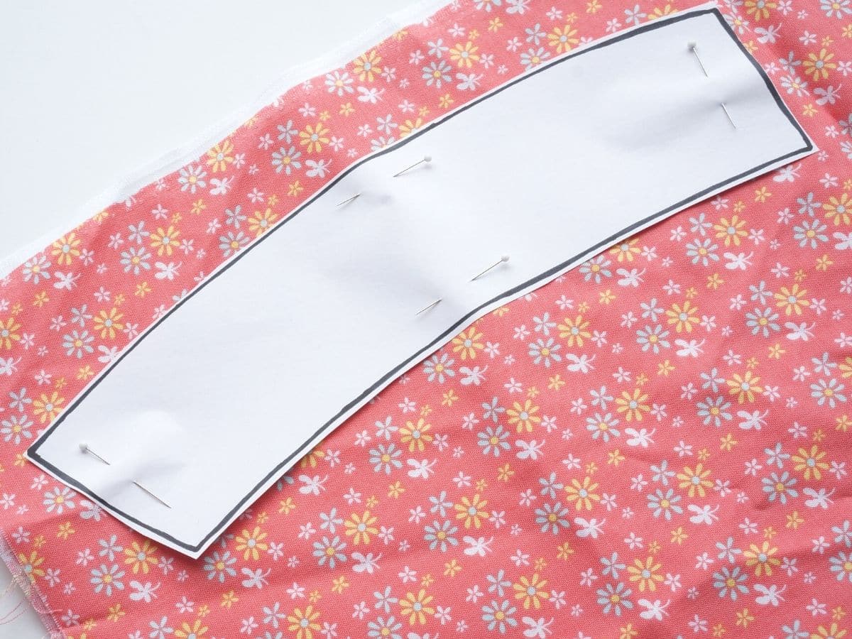 paper coffee sleeve template pinned onto flowery cotton fabric