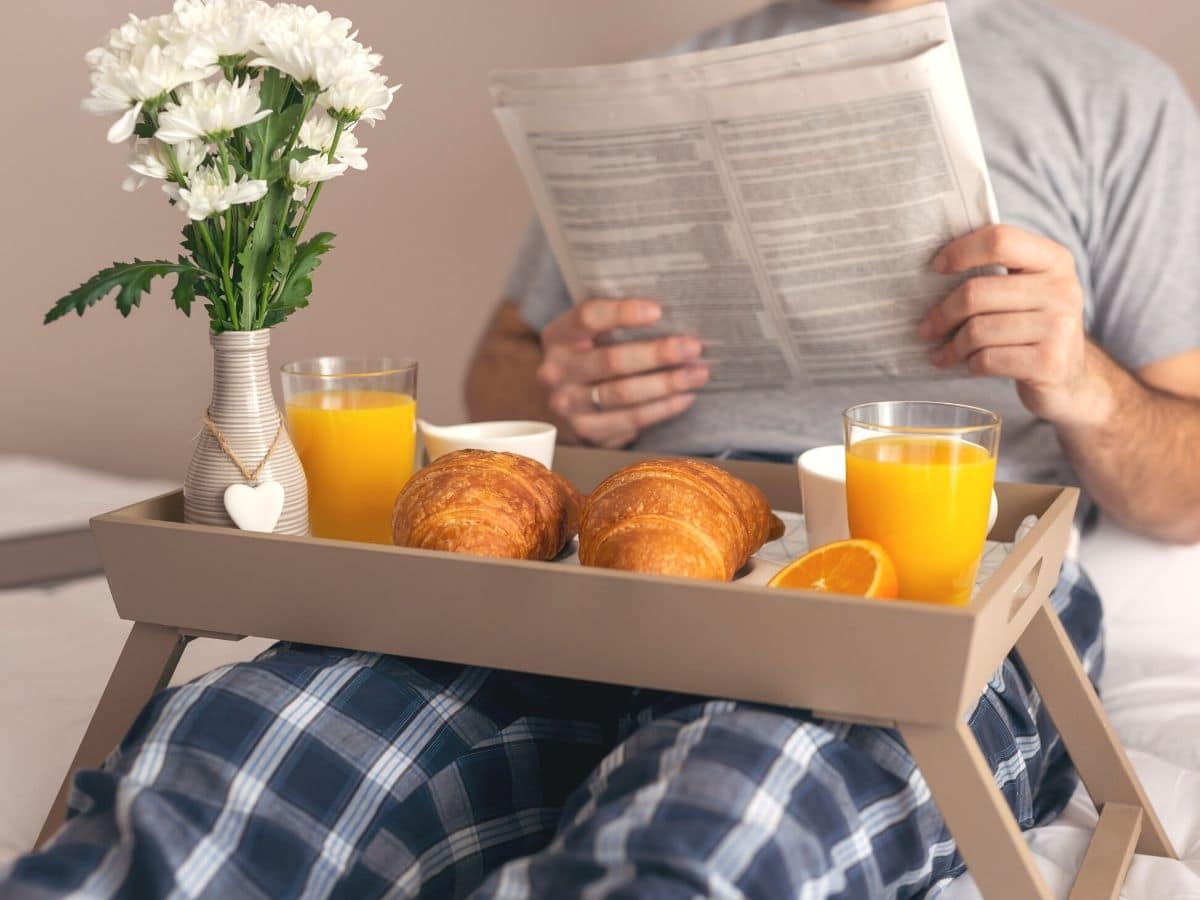 fathers day breakfast in bed table on lap of dad with newspaper