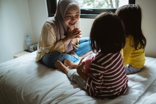 storytelling mom on bed telling a story to kids