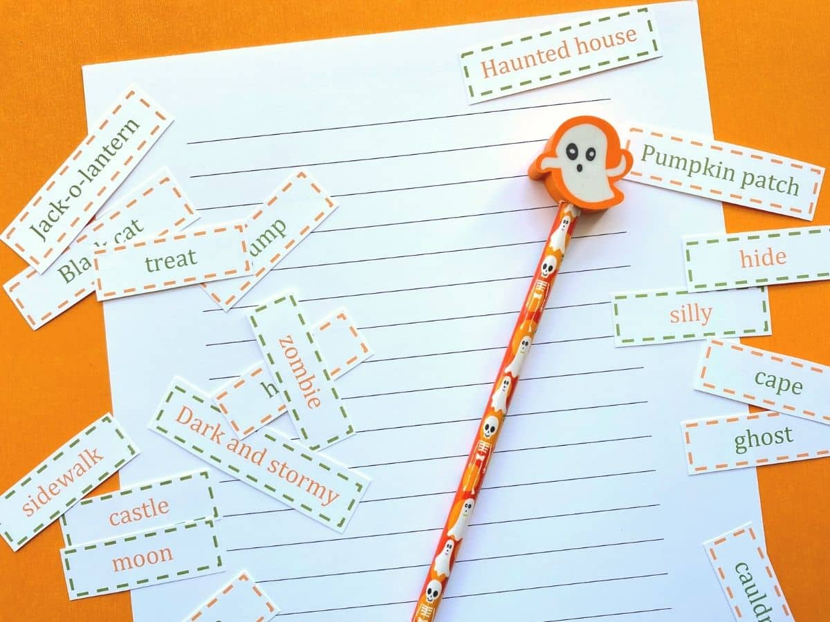 Halloween story writing prompts for kids printed out and cut out with ghost pencil
