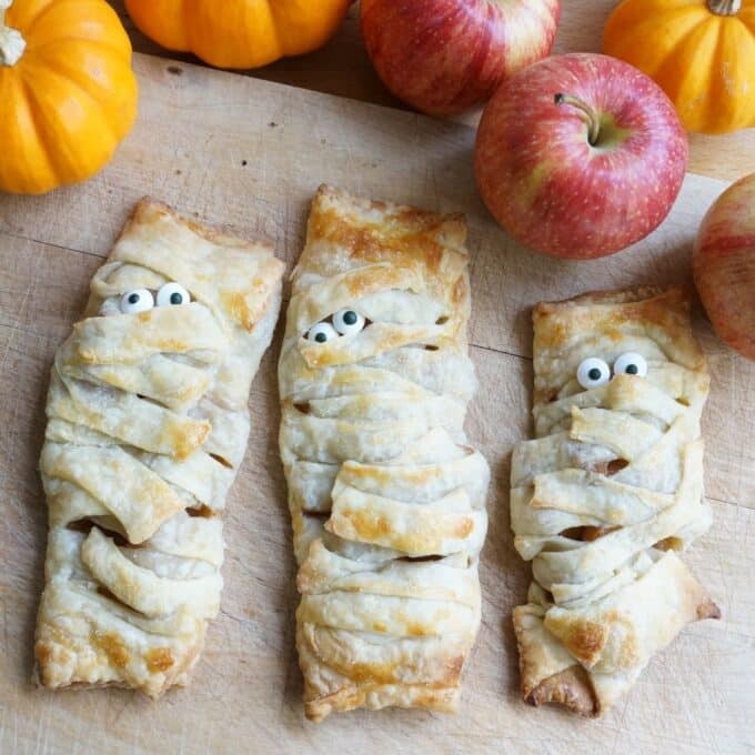 apple turnover mummies on cutting board with apples