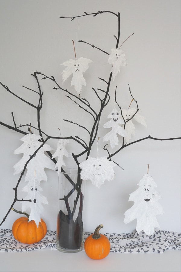 vertical image of halloween leaf ghosts in halloween tree