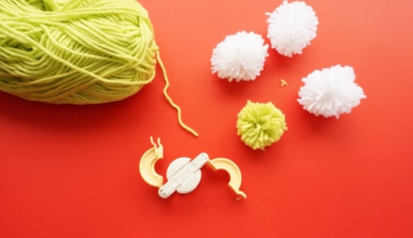 green and white pom poms with pompom maker