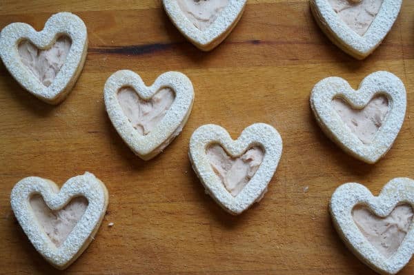 raspberry sandwich cookies on cutting board