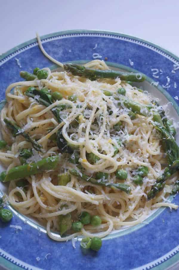creamy pasta primavera with goat cheese and parmesan cheese on top