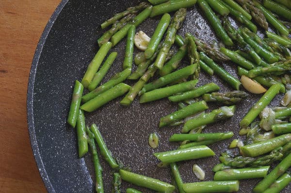 saute asparagus and onions in pan