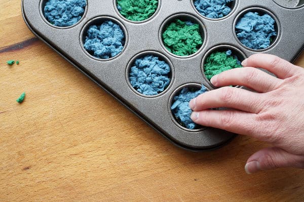 pressing the top layer of the paper mash into the seed bomb