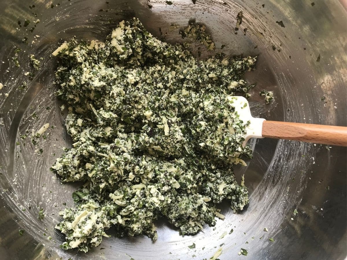 vegetarian lasagna rolls kale and cheese filling in bowl with spatula
