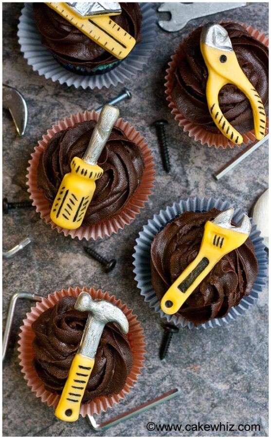 chocolate cupcakes with tools on top of them