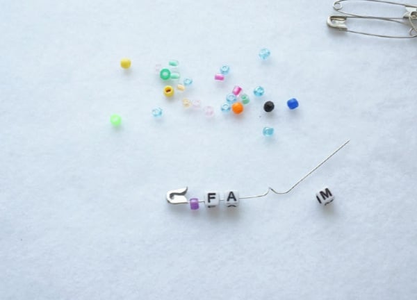 safety pin friendship pin with the letter beads being put on the pin