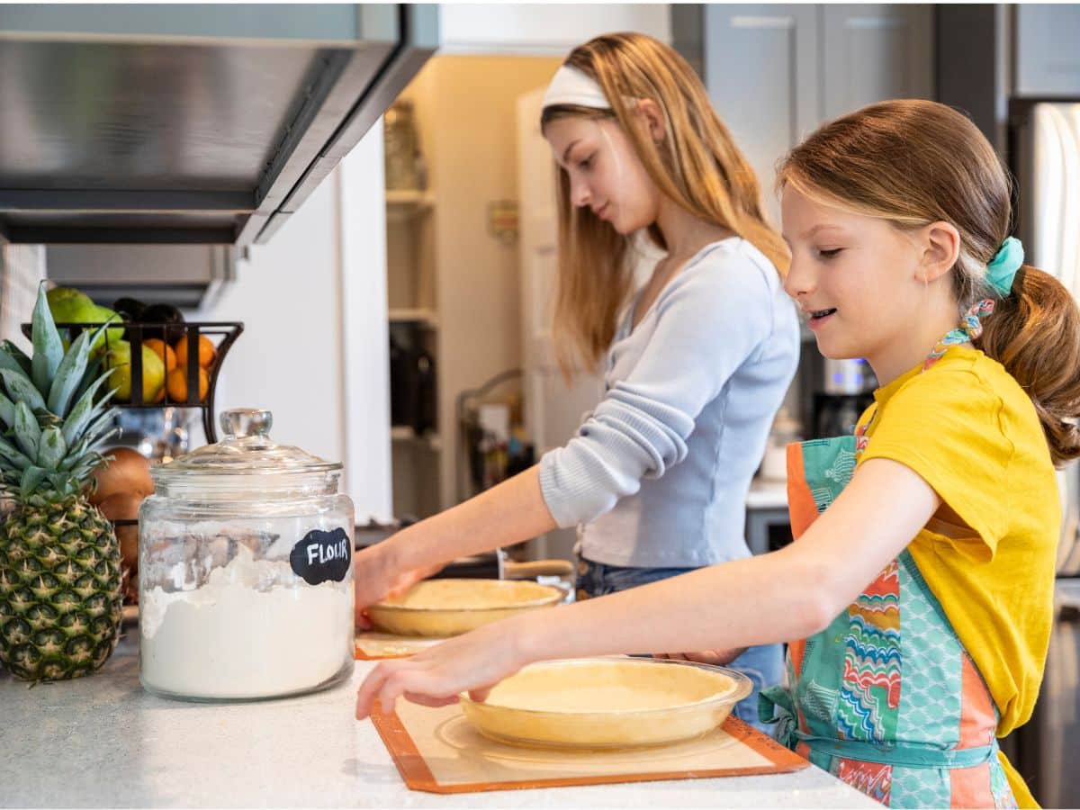 two tween girls baking pies