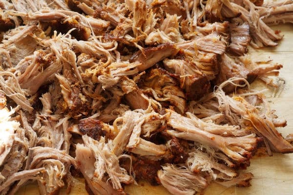 shredded pulled pork on cutting board