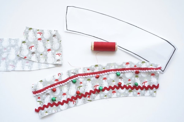 jingle bells being sewn on the coffee cup sleeve fabric