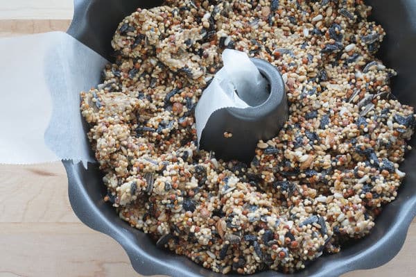 wet birdseed mixture going into bundt pan for wreath