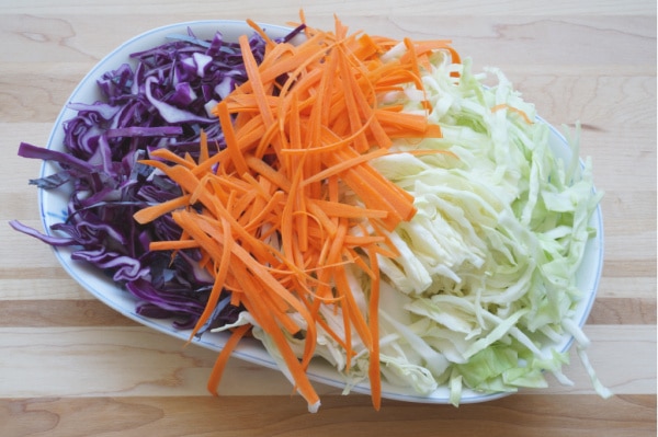 sliced carrots and cabbage for coleslaw on plate