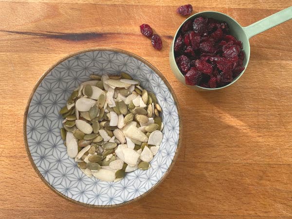 toasted slivered almonds, pumpkin seeds and cranberries on cutting board