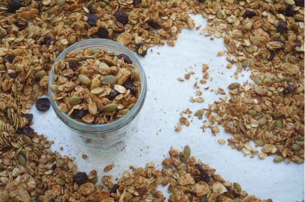pumpkin spice granola in jar on baking sheet
