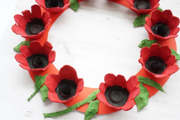 close up of egg carton poppy wreath on table