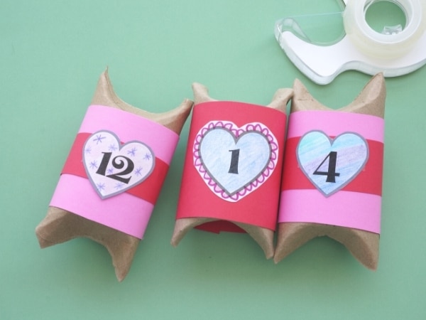 toilet paper roll boxes wrapped in pink paper and numbers taped on