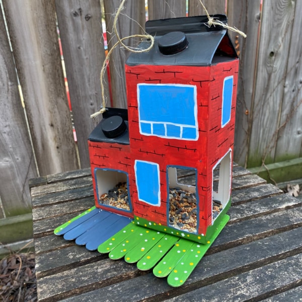 homemade bird feeder filled with bird seed sitting on table